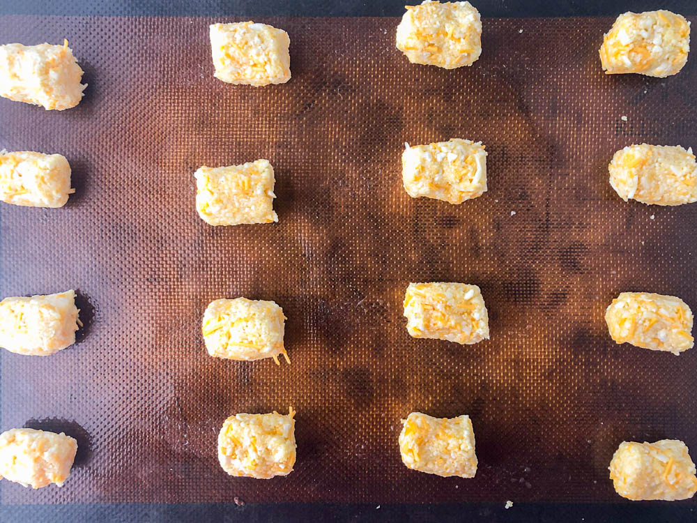 closeup of cookie sheet with raw cauliflower tots