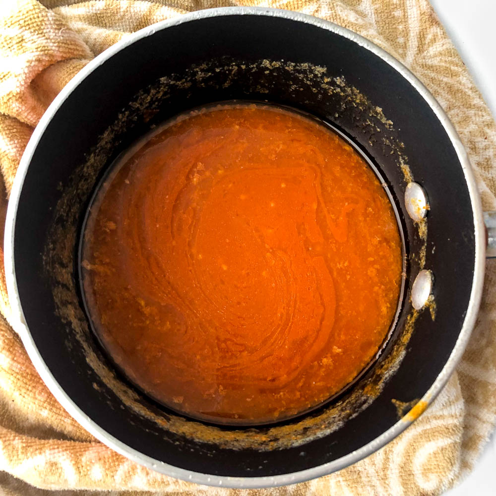 closeup of a black saucepan with keto buffalo sauce