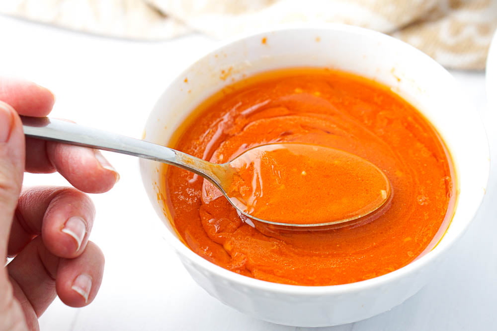 a spoonful of low carb buffalo wing sauce in a white bowl
