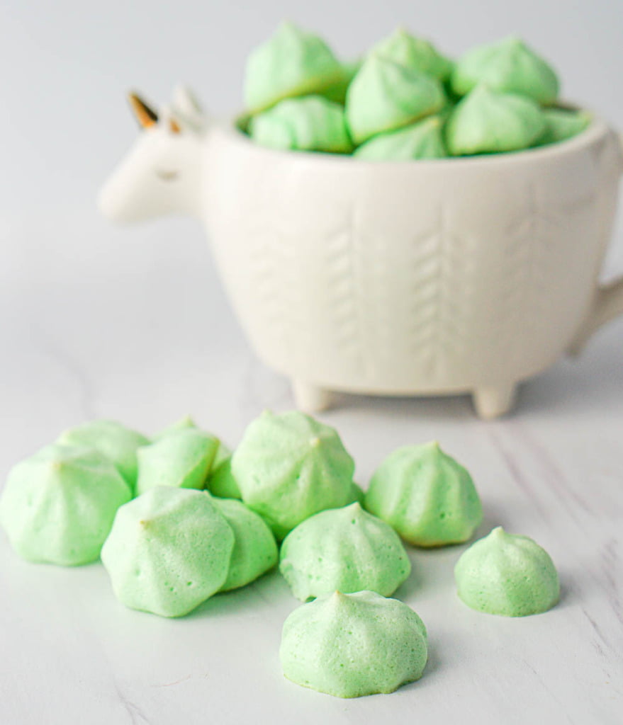 mint green meringues with the white bowl in the background