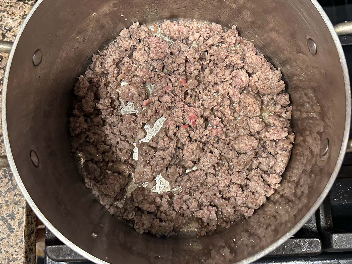 Pan with browned ground sausage.