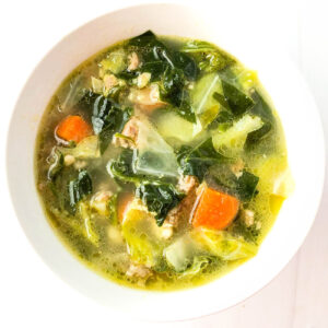 Aerial view of a white bowl of keto sausage cabbage soup.