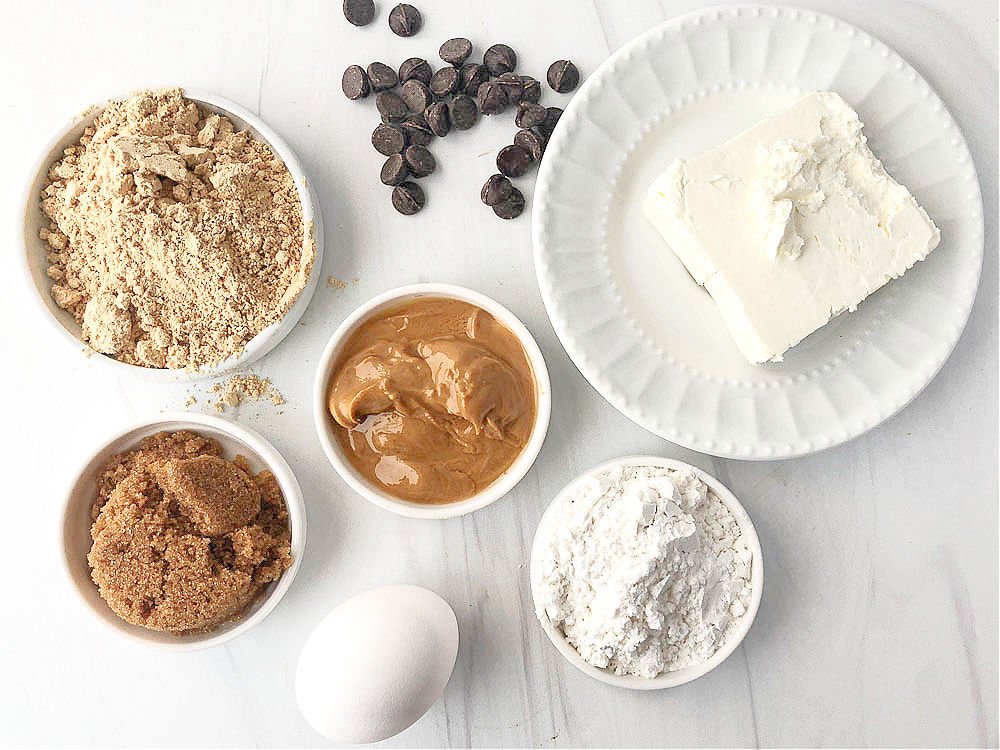 ingredients to make these cookies - cream cheese, peanut butter powder, Lilly's chocolate chips, peanut butter, Swerve brown sugar and confectioners sugar and an egg