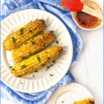white plates with spicy air fryer corn and text overlay