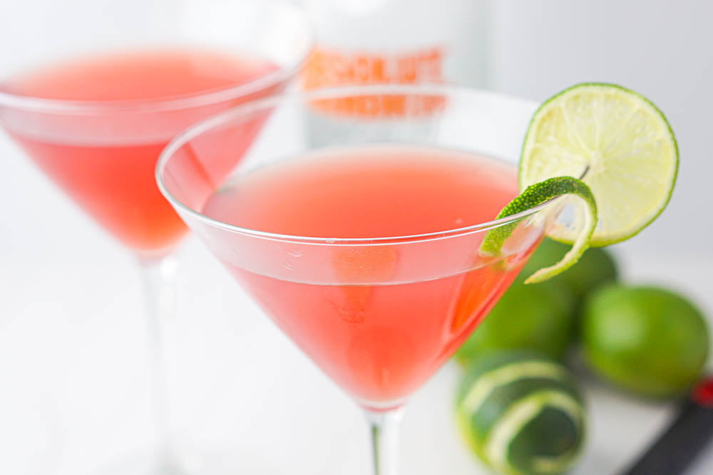closeup of 2 cosmo martinis with limes