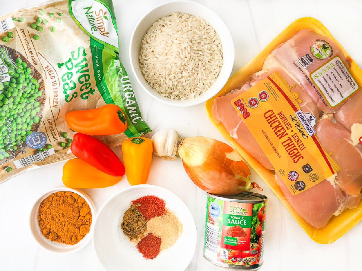 recipe ingredients - thighs, peppers, onion, garlic, rice, spices, peas and tomato sauce
