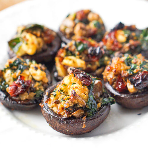 white plate with a closeup of the stuffed veggie mushrooms