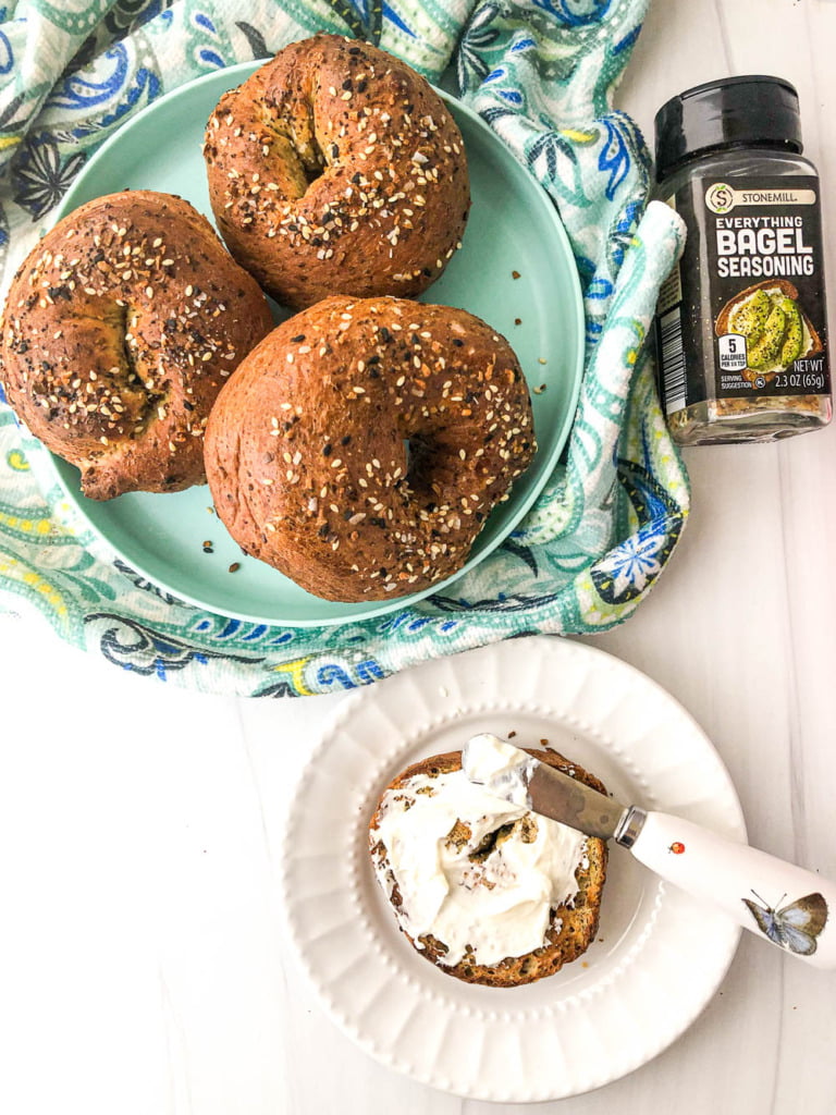aqua plate with 3 air fryer bagels and one with cream cheese and everything spice bottle
