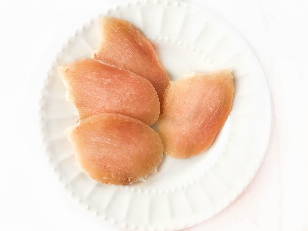 white plate with slices of raw chicken