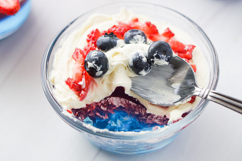 a dessert dish with a spoonful of sugar free cheesecake fluff and berries