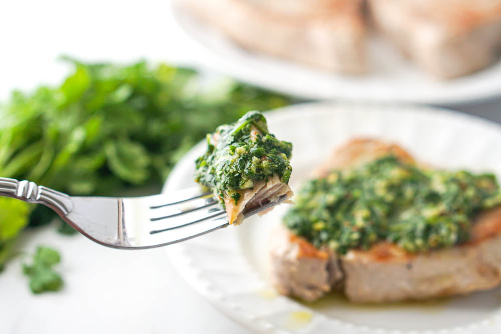 a forkful of tun steak with cilantro chimichurri sauce on top