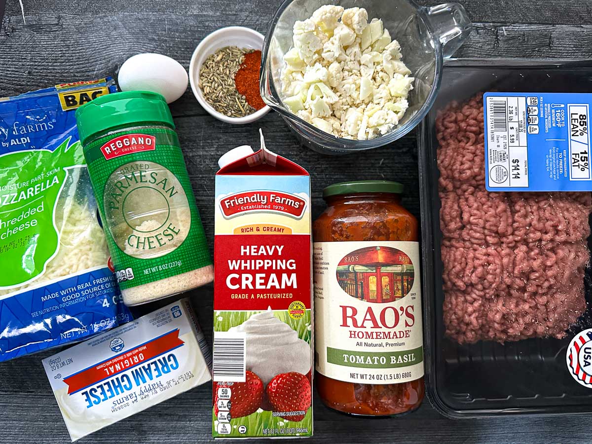 Recipe ingredients - mozzarella cheese, parmesan, egg, cream cheese, cauliflower, spices, cream, ground beef, marinara.