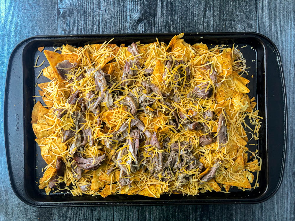 cookie tray with keto chips covered in pulled pork and shredded cheese