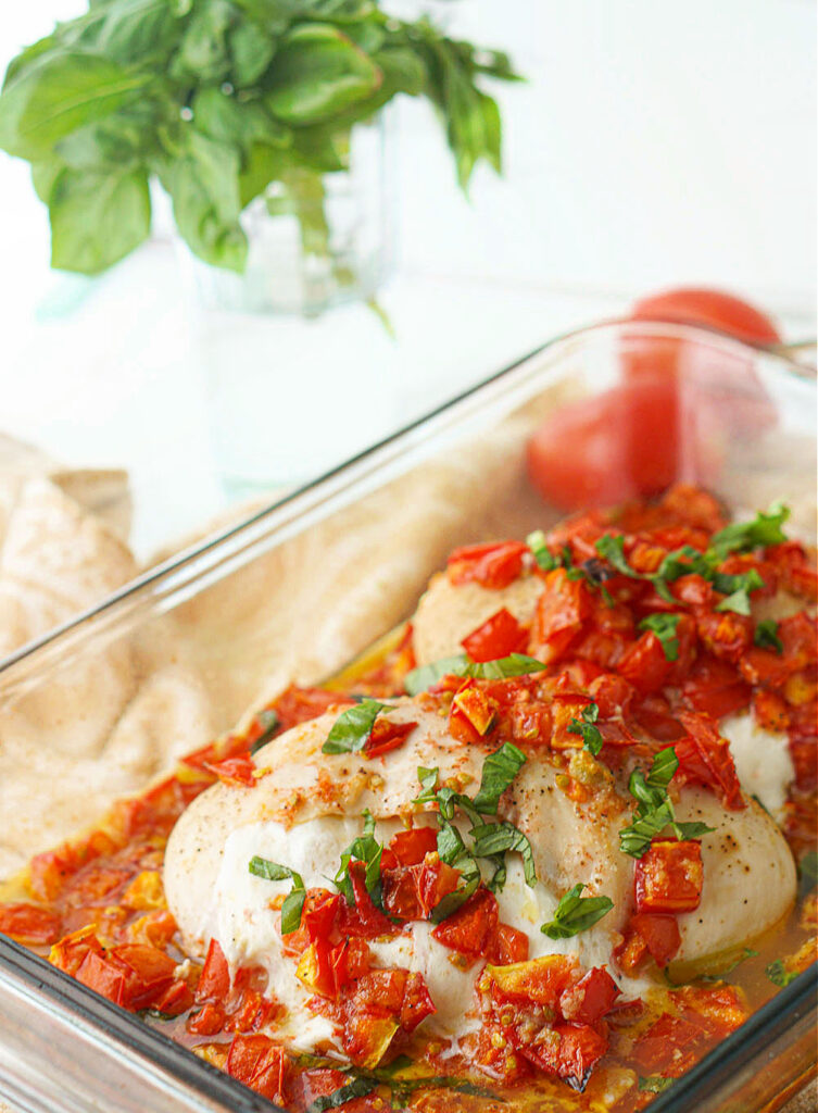 closeup of a cheese stuffed chicken breast with tomatoes and basil