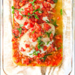 baking dish with stuffed chicken and tomatoes with text