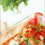 baking dish with stuffed chicken and tomatoes with text