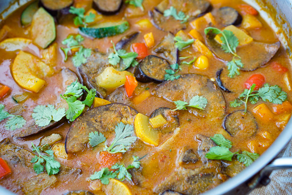 closeup of a pan of eggplant and veggie curry with fresh cilantro