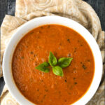 white bowl with zucchini tomato soup and text