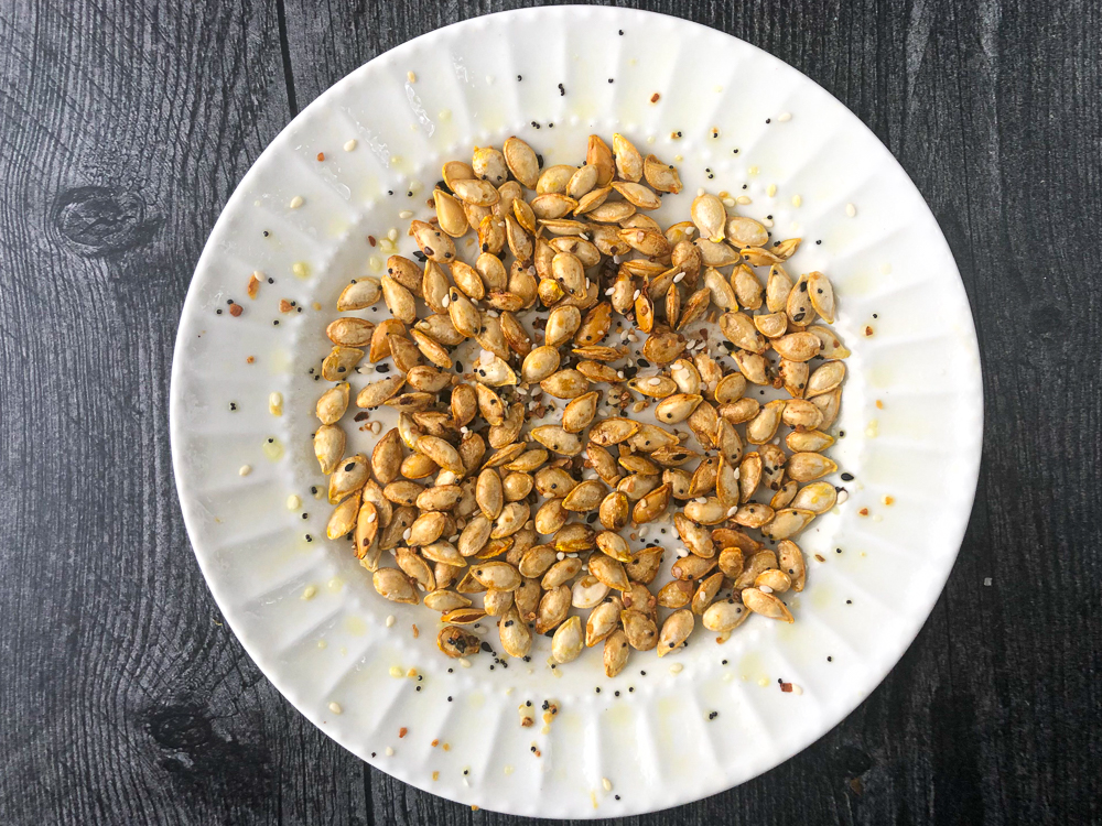 white plate with roasted butternut squash seeds