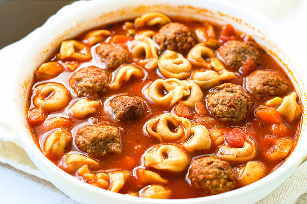 big bowl of tortellini soup with tomato broth
