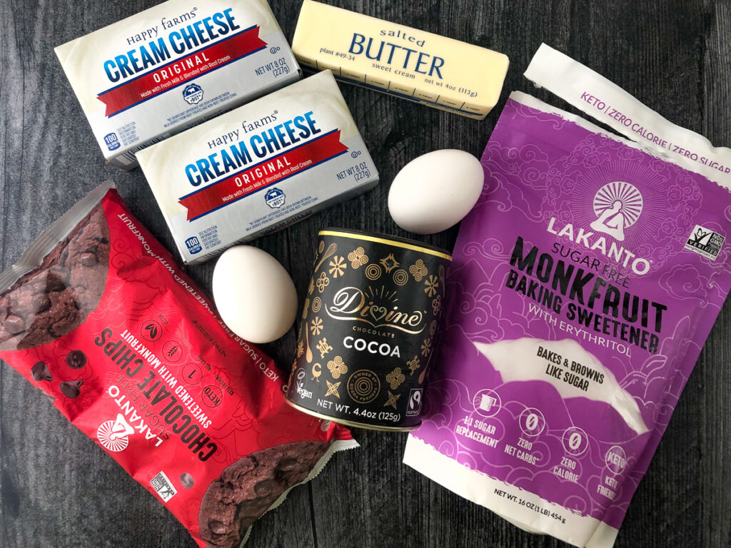 ingredients to make this keto dessert - cream cheese, eggs, butter, Divine cocoa, Lakanto chocolate chips, and Lakanto monk fruit baking sweetener