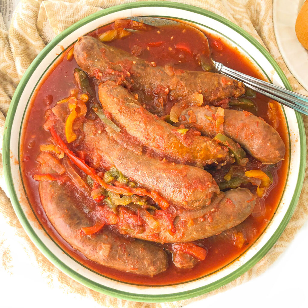 aerial view of a big bowl of slow cooker sausage and peppers with a serving fork