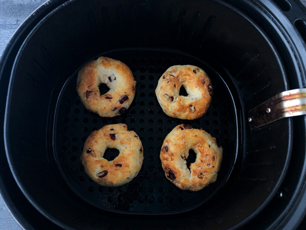 air fryer basket with 4 baked bagels 