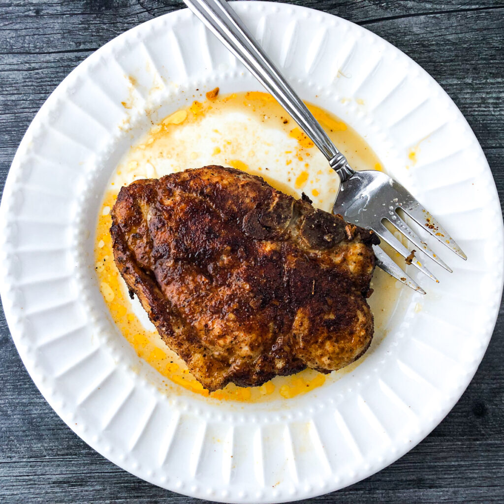 white plate and fork with an air fryer thick pork chops