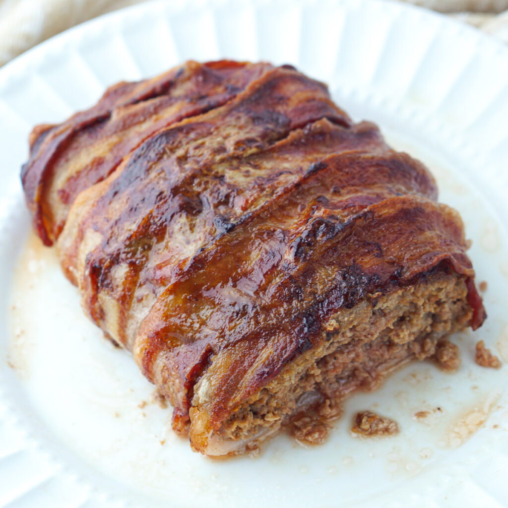 white plate with keto bacon wrapped meatloaf that was made in the air fryer