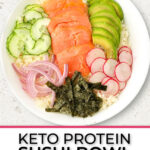 White bowl with keto California roll bowl with cauliflornia rice, smoked salmon, avocado, radish, seaweed paper, onion, cucumbers and text.