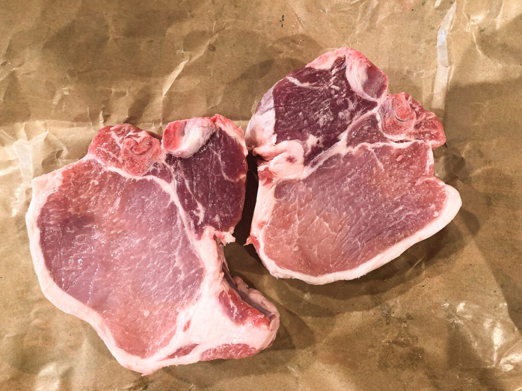 brown butcher paper with 2 raw pork rib chops