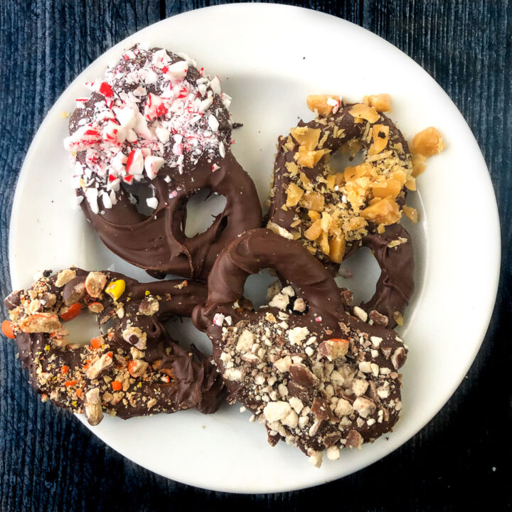A white plate with candy covered pretzels.
