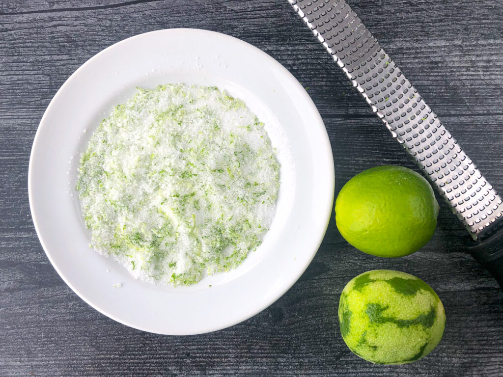 white dish with salt, sugar and lime zest for the rim of the shot glasses and a microplane and fresh limes