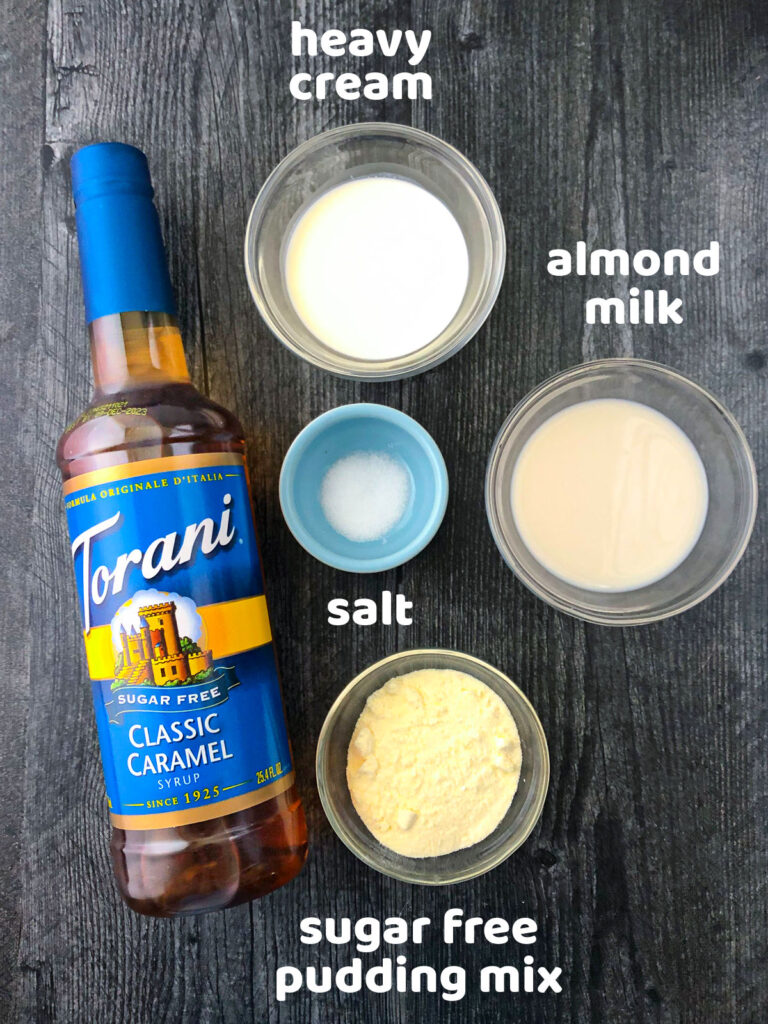 sugar free shake ingredients - bottle of caramel syrup, bowls of salt, almond milk, pudding mix and cream