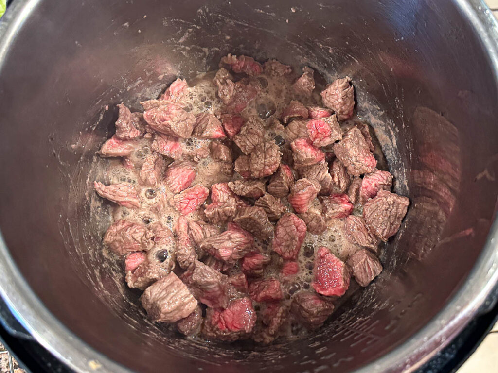 View of the pressure cooker as the meat is browning.