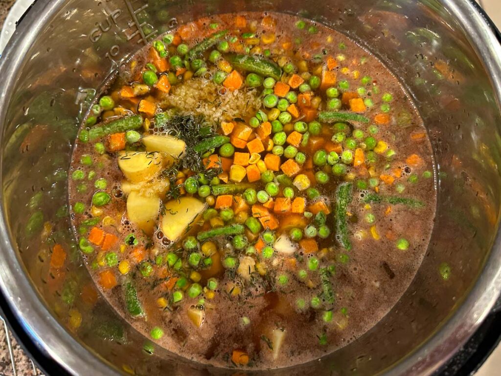 Pressure cooker pot with all the ingredients ready to cook.