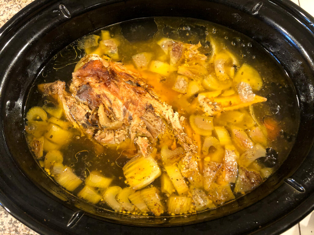 crock pot with the finished bone broth with all the cooked bones and vegetables