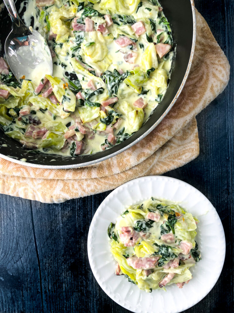 aerial view of pan and plate with creamy cabbage noodles and ham