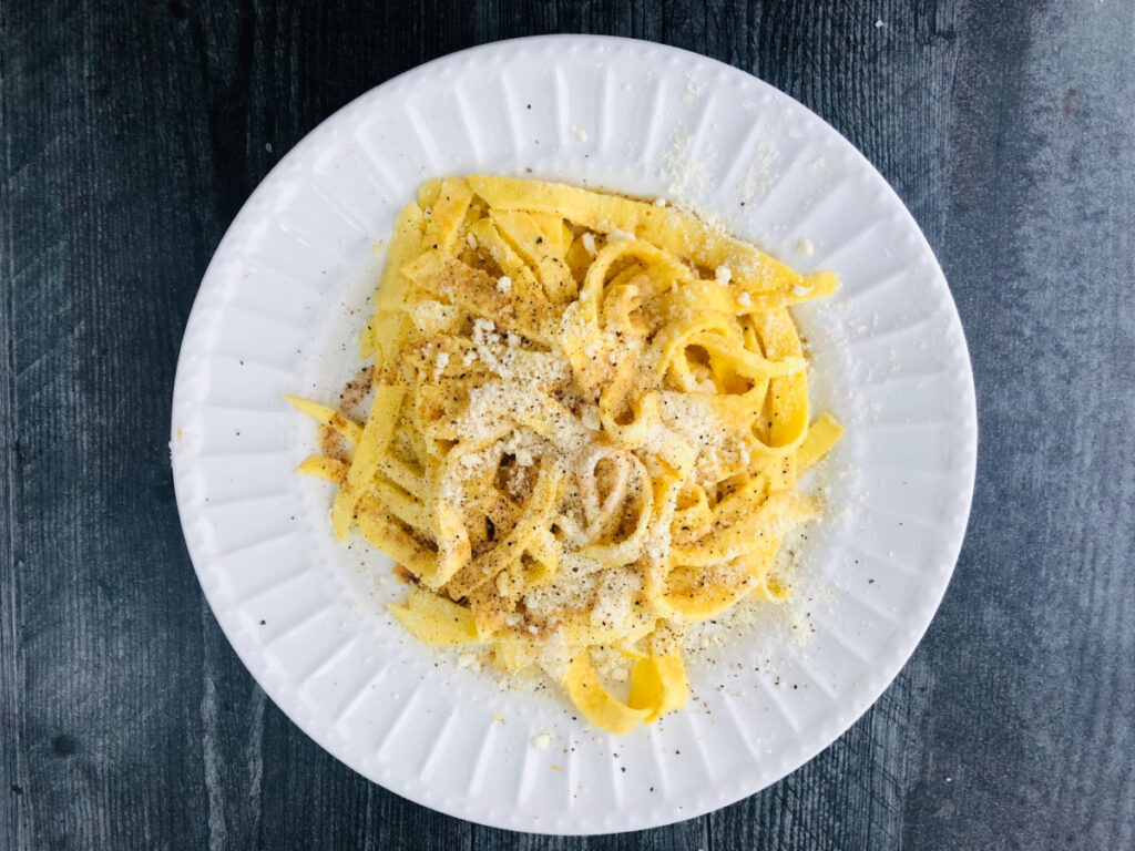 white plate with noodles made by eggs with brown butter