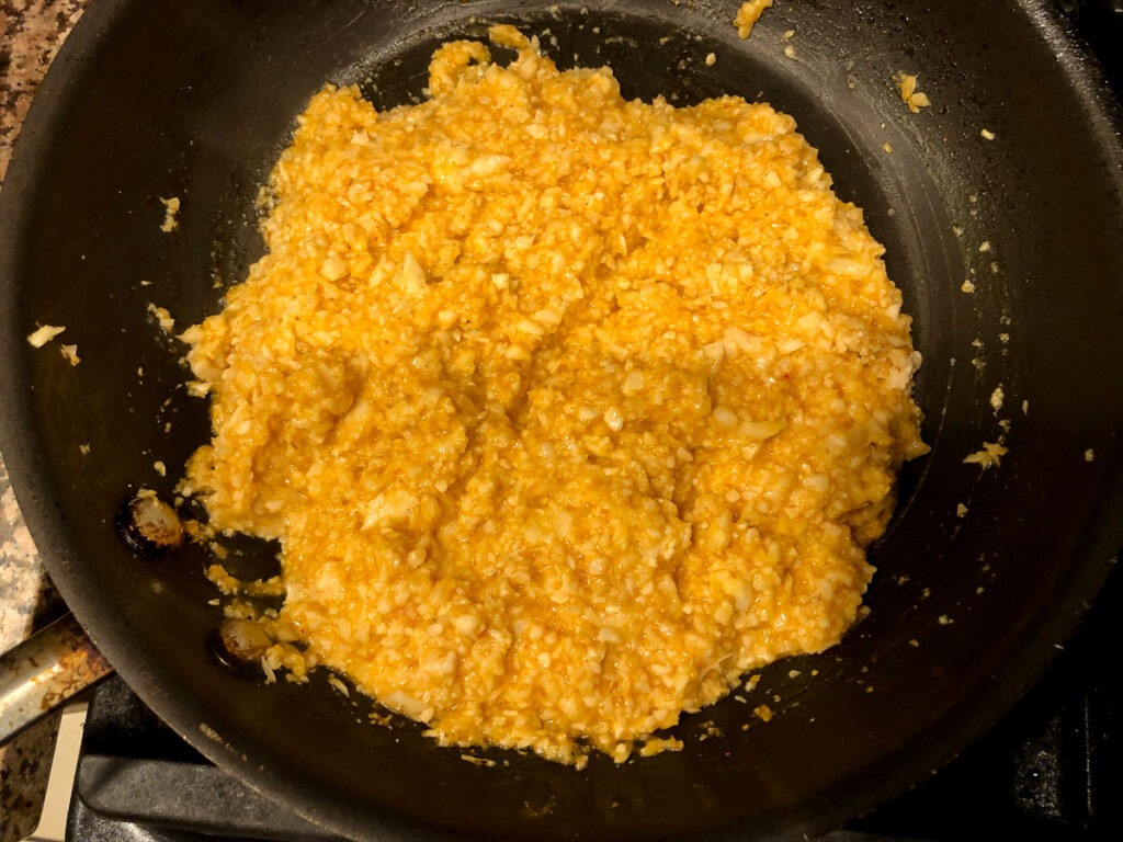 skillet with cheesy and spicy cauliflower rice