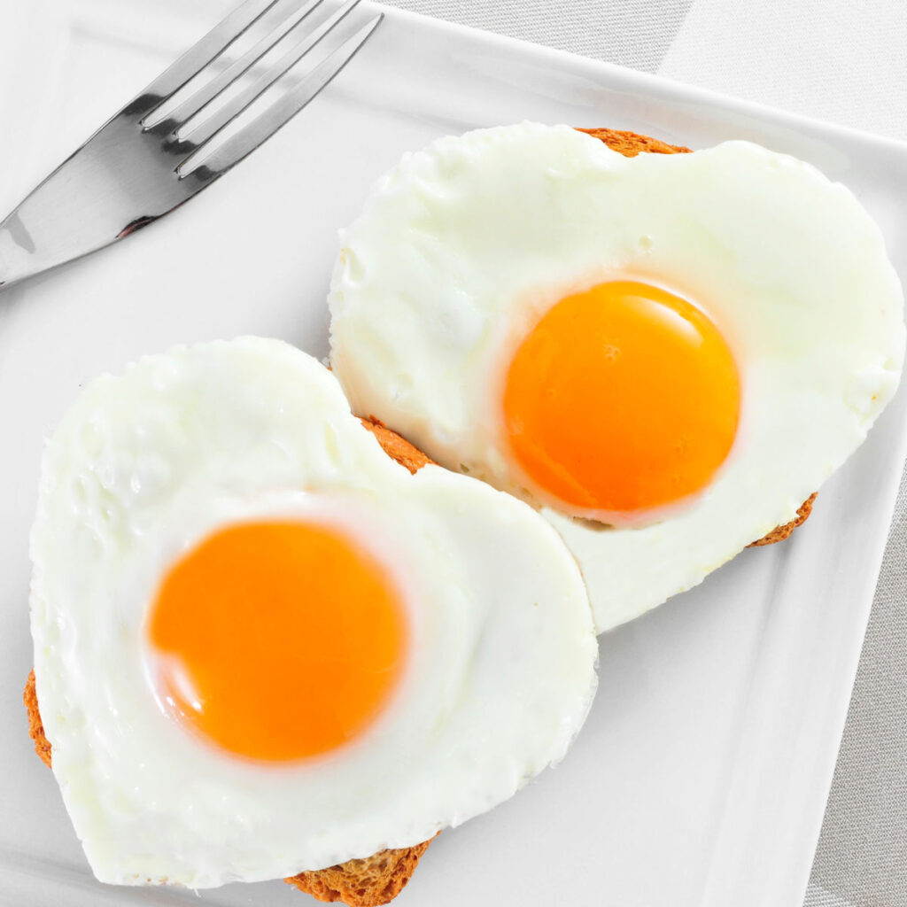 two heart shaped fried eggs on toast