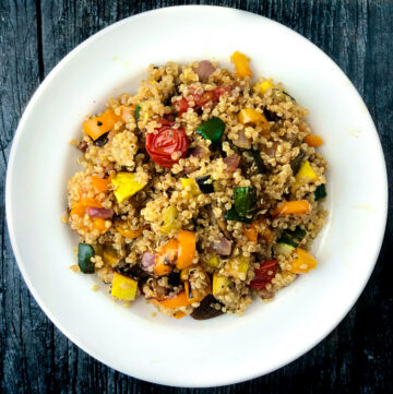 white plate with quinoa and roasted vegetables dish
