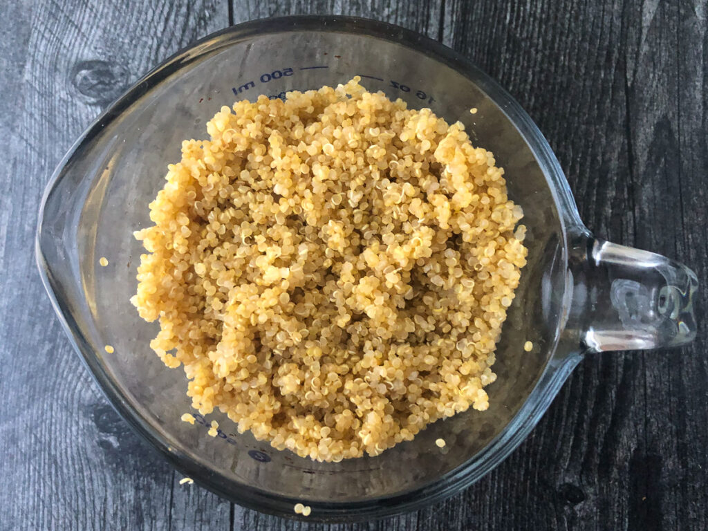 measuring cup with cooked quinoa