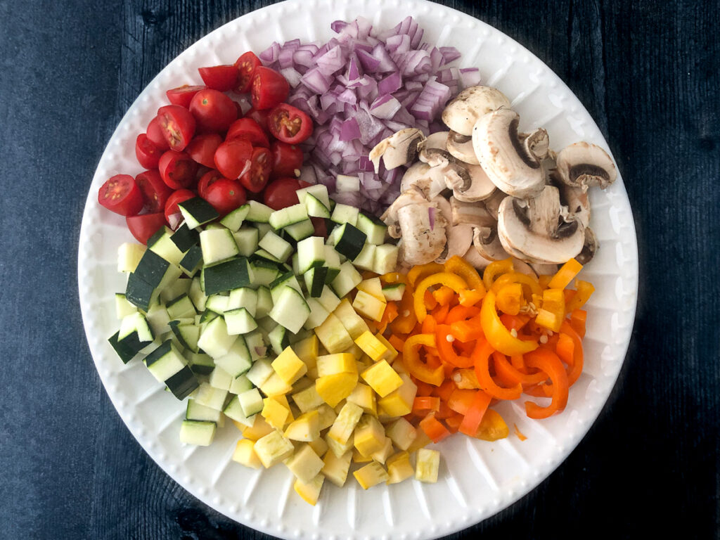white plate with chopped raw veggies