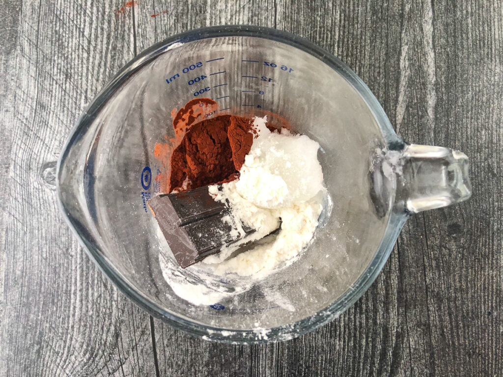 pyrex pitcher with sweetener, cocoa powder, bakers chocolate  and coconut oil