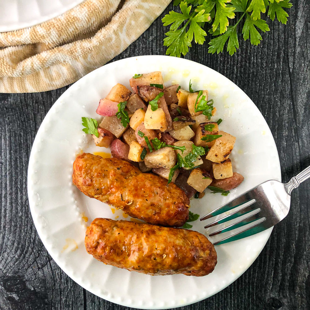 white plate with homemade Itlalian sausage  and turnip hash and a fork