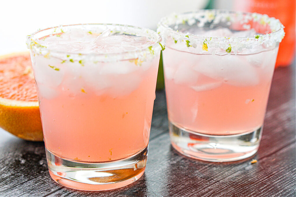 2 glasses with ice and pink sugar free  paloma drink with salted rim