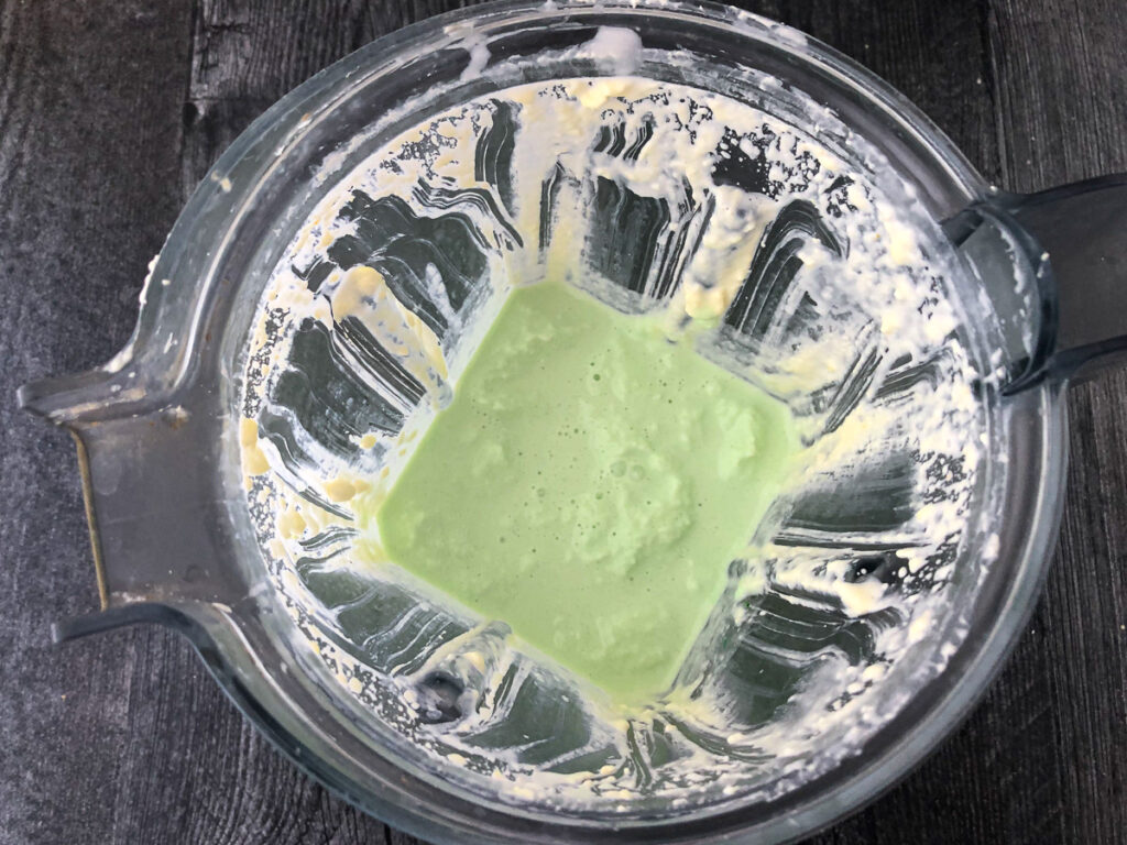 blender pitcher with green milkshake