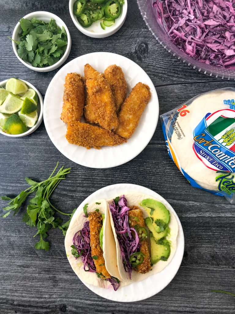 aerial views of 2 white plates with keto fish tacos and the toppings