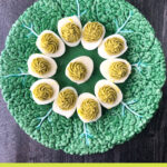 green decorative plate with keto deviled eggs with green goddess spices and text
